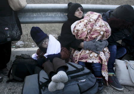 Syrian refugees rest next to a highway as a group of more than 100 Syrian refugees who crossed the Greek-Turkish land borders the previous night is stopped by Greek police near the village of Thourio at the regional unit of Evros in northeastern Greece, January 24, 2016. REUTERS/Alexandros Avramidis