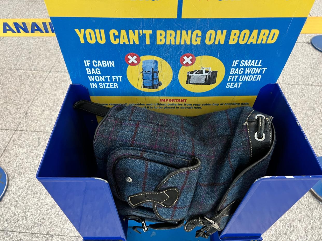 A blue rucksack in a Ryanair bag sizer at the airport