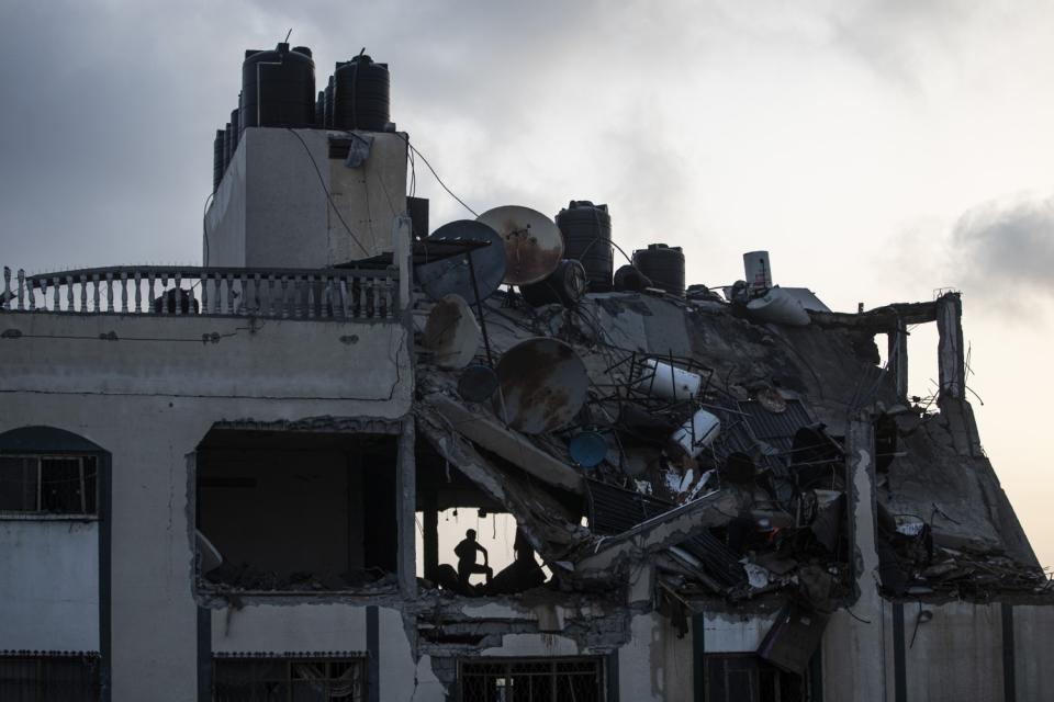 A silhouette of a person on the upper level of a damaged building