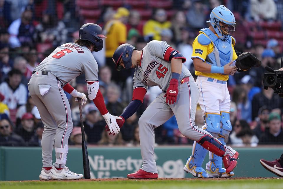 Washington Nationals' Joey Meneses (45) celebrates after his solo home run with Jesse Winker (6) beside Boston Red Sox catcher Reese McGuire, right, during the second inning of a baseball game, Saturday, May 11, 2024, in Boston. (AP Photo/Michael Dwyer)