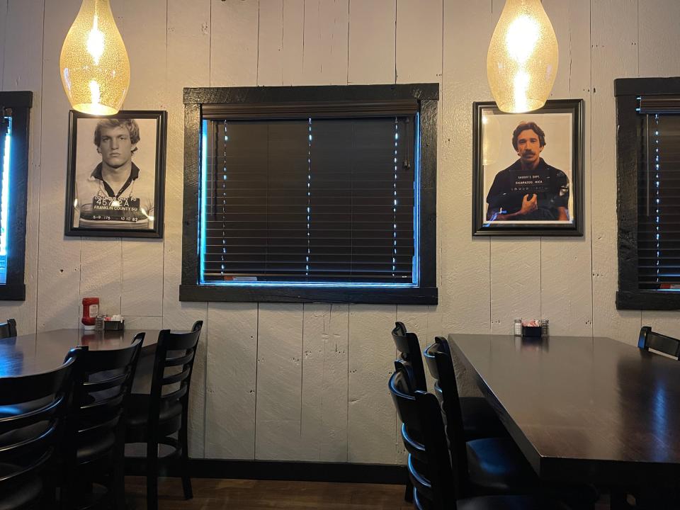 The walls are adorned with framed photos of celebrity mugshots.