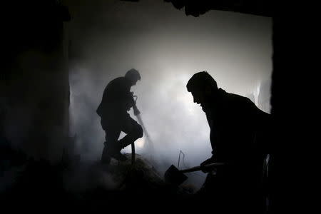 Civil defence members try to put out a fire at a site after airstrikes by pro-Syrian government forces in the rebel held Douma neighborhood of Damascus, Syria, February 14, 2016. REUTERS/Bassam Khabieh