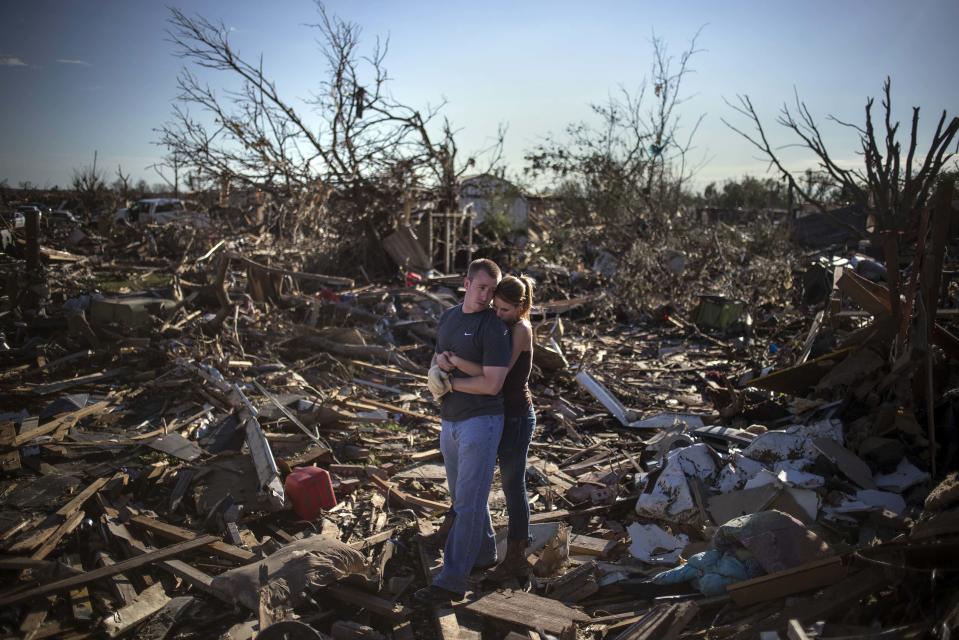 Danielle Stephan holds boyfriend Thomas Layton as they pause between salvaging through the remains of a family member's home one day after a tornado devastated the town Moore, Oklahoma, in the outskirts of Oklahoma City May 21, 2013. Rescuers went building to building in search of victims and thousands of survivors were homeless after a massive tornado tore through the Oklahoma City suburb of Moore, wiping out whole blocks of homes and killing at least 24 people. (REUTERS/Adrees Latif)