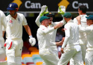 Cricket - Ashes test match - Australia v England - GABBA Ground, Brisbane, Australia, November 23, 2017. England's Alastair Cook walks off as Australian players celebrate his dismissal during the first day of the first Ashes cricket test match. REUTERS/David Gray