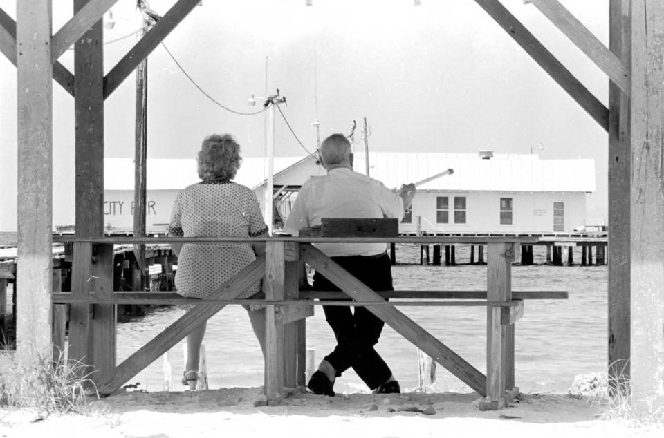 A senior couple admires the Anna Maria City Pier from a bench in the 1970s.