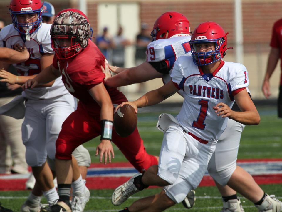 Licking Valley quarterback Hayden Rodgers looks for a receiver while evading the rush during a scrimmage against visiting Utica on Saturday, August 5, 2023.