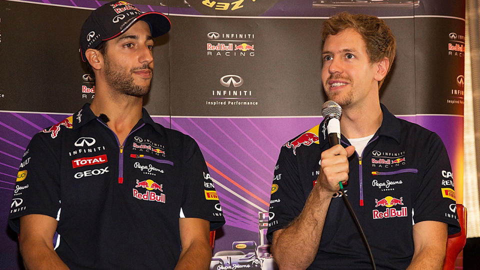 Sebastian Vettel is pictured with Daniel Ricciardo during a 2014 media appearance when the pair were F1 teammates at Red Bull Racing.