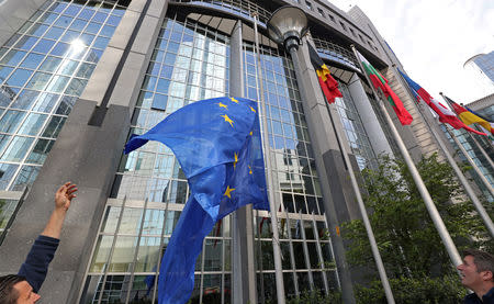 Workers adjust a European flag outside the EU Parliament ahead of the EU elections in Brussels, Belgium, May 22, 2019. REUTERS/Yves Herman