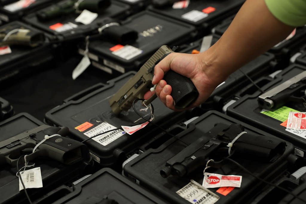 A man picks up a handgun at a gun store