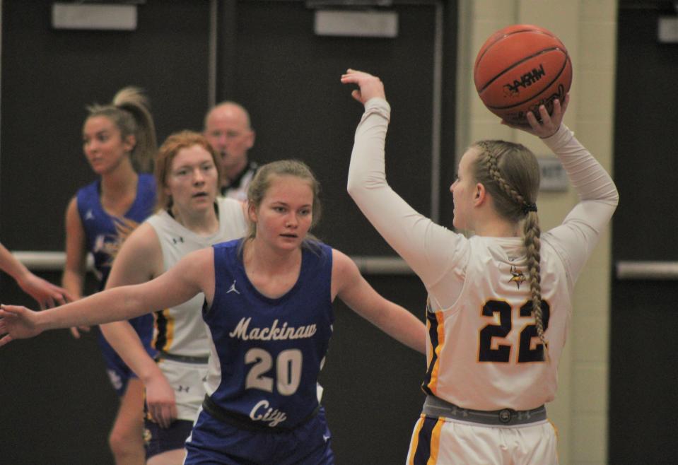 Mackinaw City junior guard Gracie Beauchamp (20) defends Baraga senior guard Corina Jahfetson (22) during the first half of Tuesday's state quarterfinal in Munising.