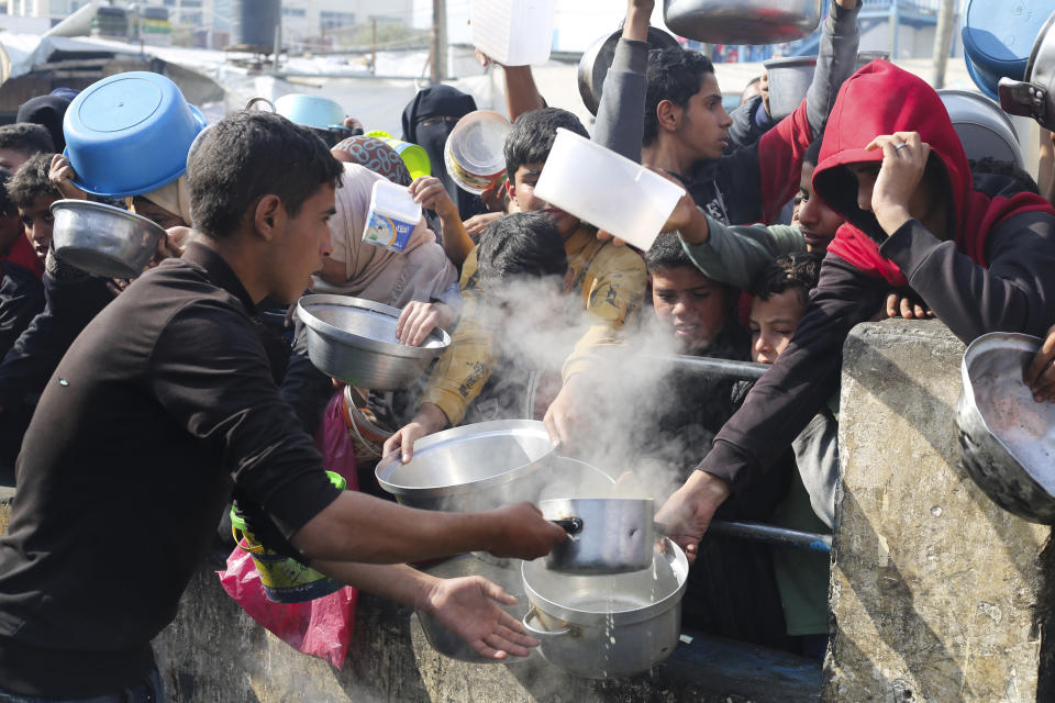 Palestinians line up for free food during the ongoing Israeli air and ground offensive on the Gaza Strip in Rafah, Tuesday, Jan. 9, 2024. (AP Photo/Hatem Ali)