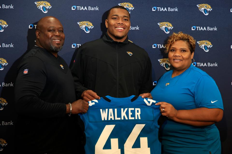 Jacksonville Jaguars first round draft pick Travon Walker, center, is flanked by his father and mother, Stead Walker and Lasonia Walker, respectively, as he holds up his new jersey during a press conference Friday, April 29, 2022 at TIAA Bank Field in Jacksonville. Walker, a defensive lineman from the University of Georgia, was the overall No. 1 pick for the Jacksonville Jaguars in the 2022 NFL Draft. 