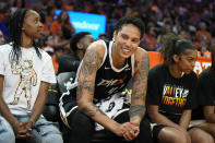 Phoenix Mercury center Brittney Griner smiles at the fans as she sits between Mercury's Shey Peddy, left, and Evina Westbrook, right, during the first half of a WNBA basketball game against the Chicago Sky, Sunday, May 21, 2023, in Phoenix. (AP Photo/Ross D. Franklin)