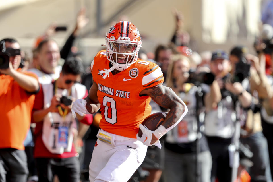 FILE - Oklahoma State's Ollie Gordon II (0) celebrates in the end zone after scoring a touchdown during the first half of an NCAA college football game against Kansas in Stillwater, Okla., Saturday, Oct. 14, 2023. Gordon was selected as the Associated Press Big 12 Offensive player of the year. (AP Photo/Mitch Alcala, File)