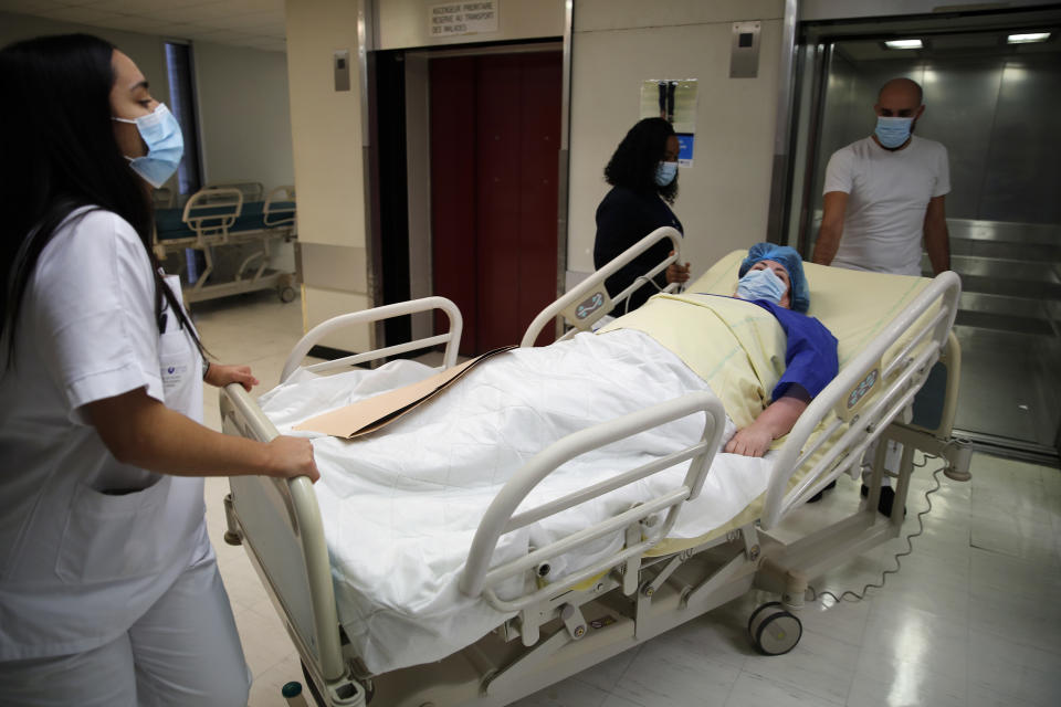 Caroline Erganian, a retired secretary, is moved on a gurney for her surgery at Bichat Hospital, AP-HP, in Paris, Wednesday, Dec. 2, 2020. (AP Photo/Francois Mori)