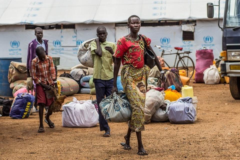 At Elegu Collection Point, a family of refugees carries their luggage for relocation to Bidi Bidi settlement. <i>Location: Elegu Collection Point, Oct. 27, 2016.</i>