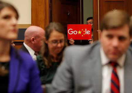 A demonstrator holds up a sign in the doorway as Google CEO Sundar Pichai testifies at a House Judiciary Committee on greater transparency in Washington, U.S., December 11, 2018. REUTERS/Jim Young