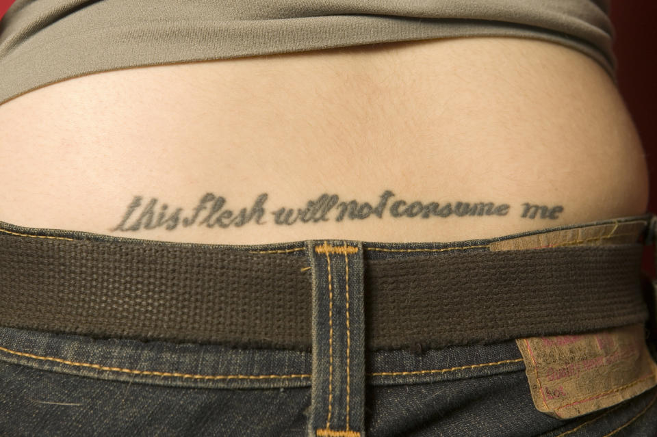 A tattoo saying, "this flesh will not consume me"