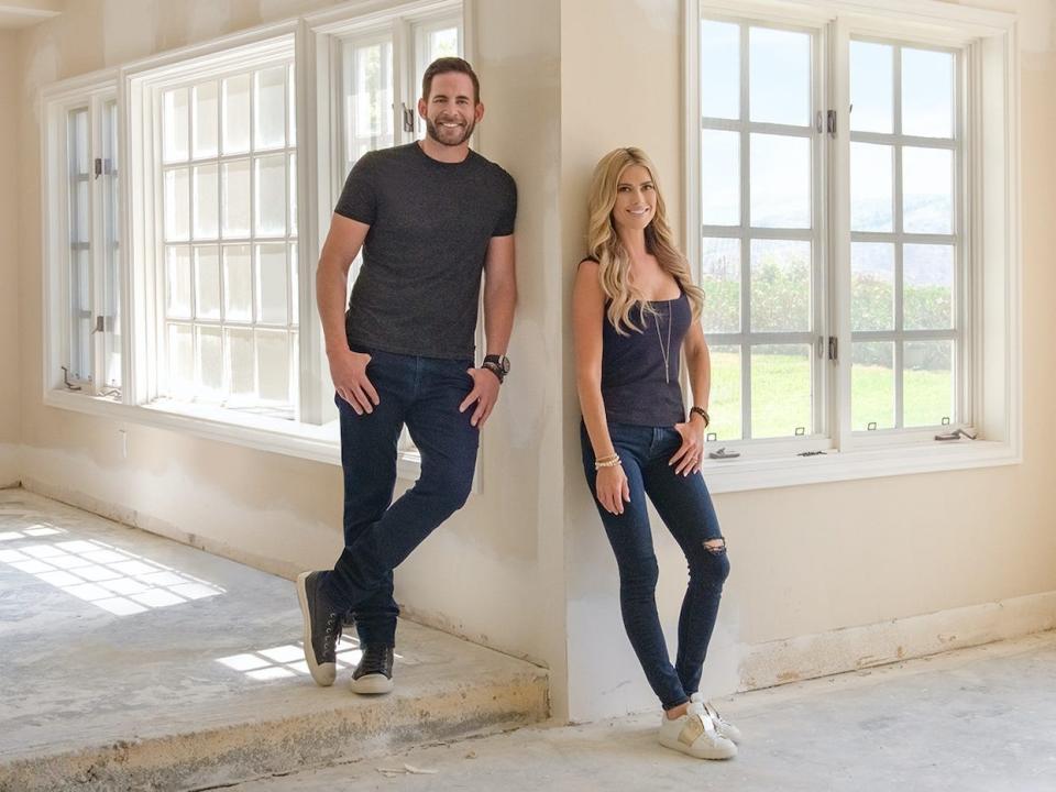 Tarek El Moussa and Christina Haack pose in an empty house.