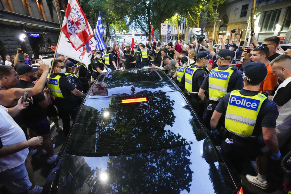 FILE - Fans of Serbian Novak Djokovic surround a car as it leaves the offices of lawyers following his court win ahead of the Australian Open in Melbourne, Australia, Jan. 10, 2022. His visa, however, was canceled again for the coronavirus-related issues, and Djokovic was eventually deported. (AP Photo/Mark Baker, File)