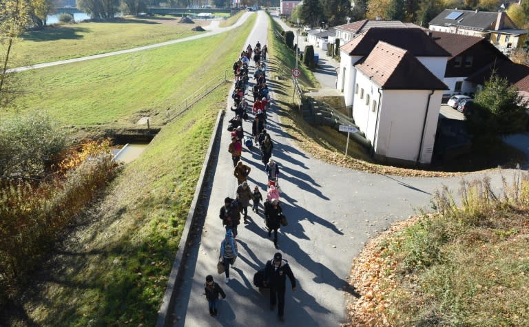 Migrants walk to a registration point of the German federal police after crossing the Austrian-German border near the Bavarian village of Simbach