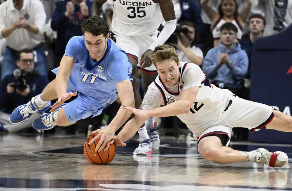 Creighton center Ryan Kalkbrenner, left, and UConn guard Cam Spencer dive for the ball in the second half of an NCAA college basketball game, Wednesday, Jan. 17, 2024, in Stores, Conn. (AP Photo/Jessica Hill)