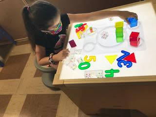 Savanah Bowen sits at a light table working on math concepts in a new STEM learning lab at a Head Start classroom in Connellsville Township in Fayette County.