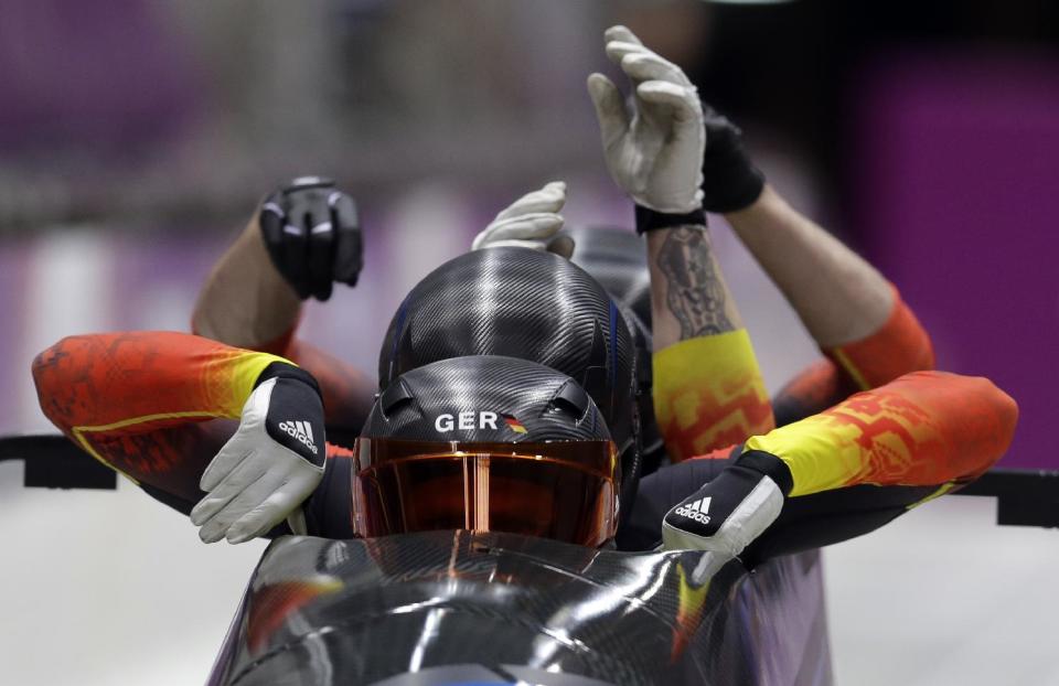 The team from Germany GER-1, with Maximilian Arndt, Marko Huebenbecker, Alexander Roediger and Martin Putze, start their first run during the men's four-man bobsled competition at the 2014 Winter Olympics, Saturday, Feb. 22, 2014, in Krasnaya Polyana, Russia. (AP Photo/Natacha Pisarenko)