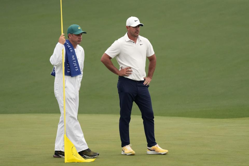 Apr 7, 2023; Augusta, Georgia, USA; Brooks Koepka (right) and caddie Ricky Elliott look on from the second green during the second round of The Masters golf tournament. Mandatory Credit: Michael Madrid-USA TODAY Network