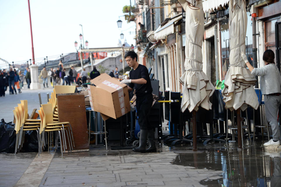 A man cleans up following a flooding in Venice, Italy, Thursday, Nov. 14, 2019. The worst flooding in Venice in more than 50 years has prompted calls to better protect the historic city from rising sea levels as officials calculated hundreds of millions of euros in damage. The water reached 1.87 meters above sea level Tuesday, the second-highest level ever recorded in the city. (Andrea Merola/ANSA via AP)