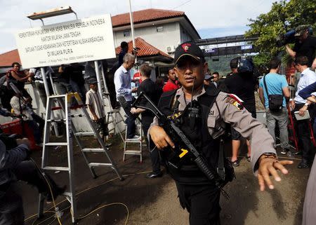 An Indonesian policeman stands guard in front of Wijayapura port near the prison island of Nusa Kambangan in Cilacap, Central Java island, Indonesia, April 28, 2015. REUTERS/Beawiharta