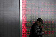 An investor prepares to leave a quiet brokerage house in Beijing, Wednesday, March 27, 2019. Shares were mixed in Asia early Wednesday after U.S. stocks finished broadly higher on Wall Street, erasing modest losses from a day earlier. (AP Photo/Andy Wong)