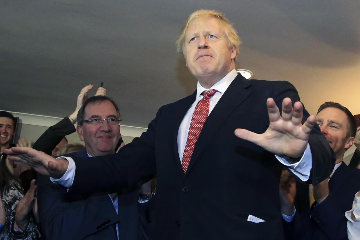 Britain's Prime Minister Boris Johnson gestures as he speaks to supporters on a visit to meet newly elected Conservative party MP for Sedgefield, Paul Howell, at Sedgefield Cricket Club in County Durham, north east England, Saturday Dec. 14, 2019, following his Conservative party's general election victory.  Johnson called on Britons to put years of bitter divisions over the country's EU membership behind them as he vowed to use his resounding election victory to finally deliver Brexit. (Lindsey Parnaby/Pool via AP)