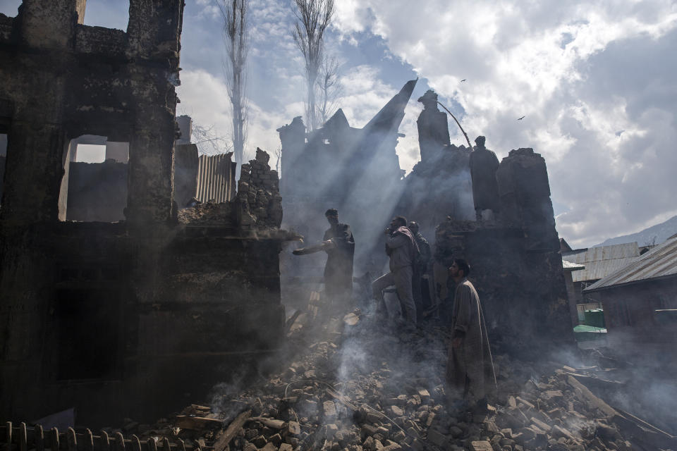 Kashmiri men dismantle a portion of a house destroyed in a gunbattle in Tral village, south of Srinagar, Indian controlled Kashmir, March 4, 2019. The image was part of a series of photographs by Associated Press photographers which won the 2020 Pulitzer Prize for Feature Photography. (AP Photo/Dar Yasin)