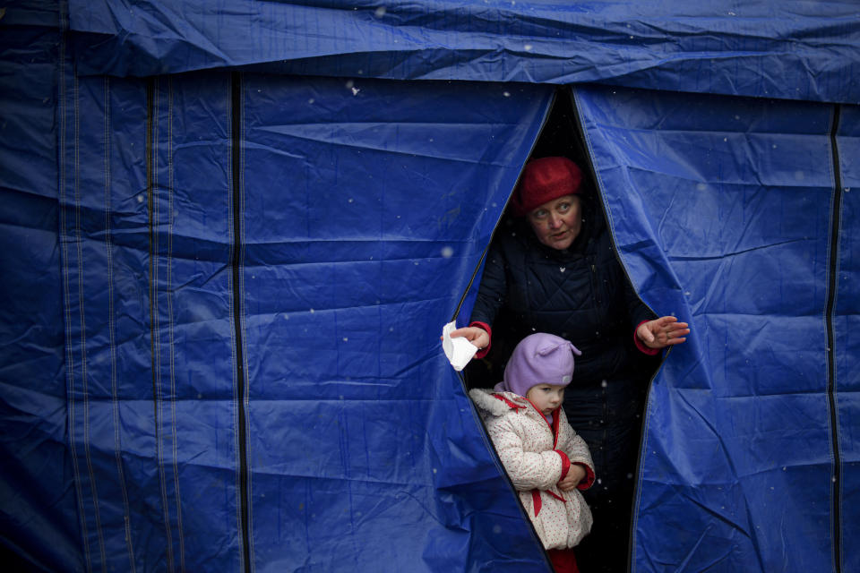 Refugees fleeing the conflict from neighbouring Ukraine exit a tent at the Romanian-Ukrainian border, in Siret, Romania, Thursday, March 3, 2022. The number of people sent fleeing Ukraine by Russia's invasion topped 1 million on Wednesday, the swiftest refugee exodus this century, the United Nations said, as Russian forces kept up their bombardment of the country's second-biggest city, Kharkiv, and laid siege to two strategic seaports. (AP Photo/Andreea Alexandru)