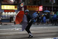 In this Oct. 6, 2019, photo, protestors clash with police in Hong Kong. Shouting "Wearing mask is not a crime," tens of thousands of protesters braved the rain Sunday to march in central Hong Kong as a court rejected a second legal attempt to block a mask ban aimed at quashing violence during four months of pro-democracy rallies. (AP Photo/Vincent Thian, File)