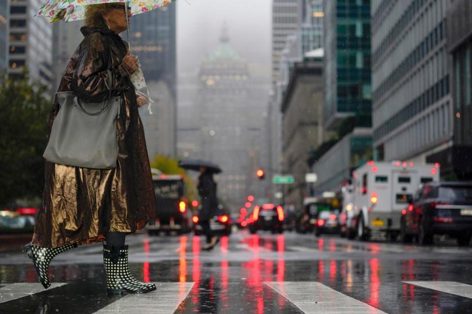 Pedestrians make their way through a rainy and foggy New York, Tuesday, Oct. 26, 2021.