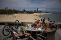 In this Monday, June 1, 2020 photo, local customers sit in a restaurant next to the beach in Barcelona. Amid the global economic slowdown provoked by the pandemic, Spain's government forecasts its economy will shrink by 9% and unemployment to reach 19% this year. Spain's strict lockdown that it is now scaling back managed to eventually control a COVID-19 outbreak that has claimed at least 27,000 lives. (AP Photo/Emilio Morenatti)