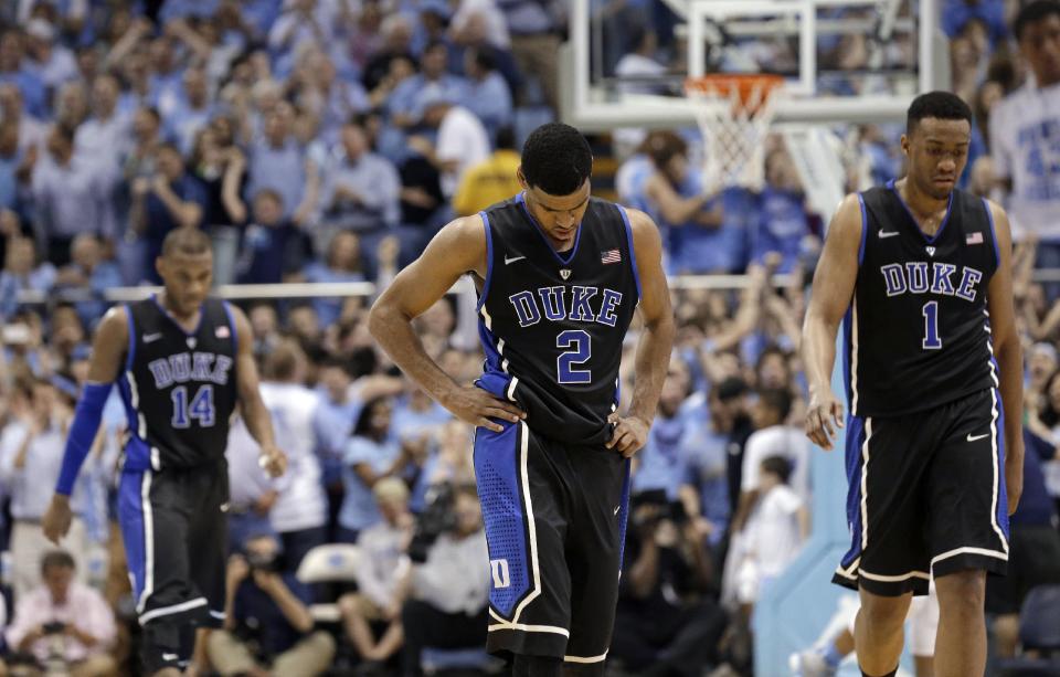 Duke's Rasheed Sulaimon (14), Quinn Cook (2) and Jabari Parker (1) walk off the court during the closing moments of an NCAA college basketball game against North Carolina in Chapel Hill, N.C., Thursday, Feb. 20, 2014. North Carolina won 74-66. (AP Photo/Gerry Broome)