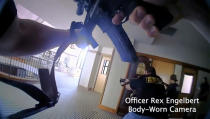 This image provided by Metropolitan Nashville Police Department shows bodycam footage of police responding to an active shooting at The Covenant School in Nashville, Tenn., on Monday, March 27, 2023. The former student who shot through the doors of the Christian elementary school and killed three children and three adults had drawn a detailed map of the school. (Metropolitan Nashville Police Department via AP)