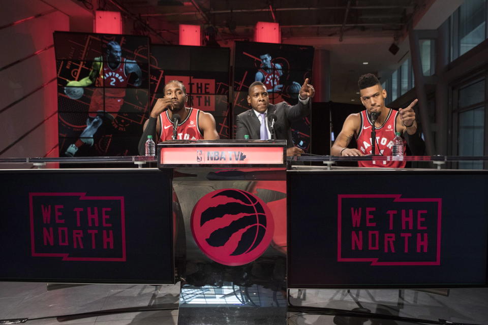 Toronto Raptors' Kawhi Leonard, left to right, sits alongside Raptors President Masai Ujiri and Danny Green at a press conference during the NBA basketball team's media day in Toronto, Monday, Sept. 24, 2018. (Chris Young/The Canadian Press via AP)