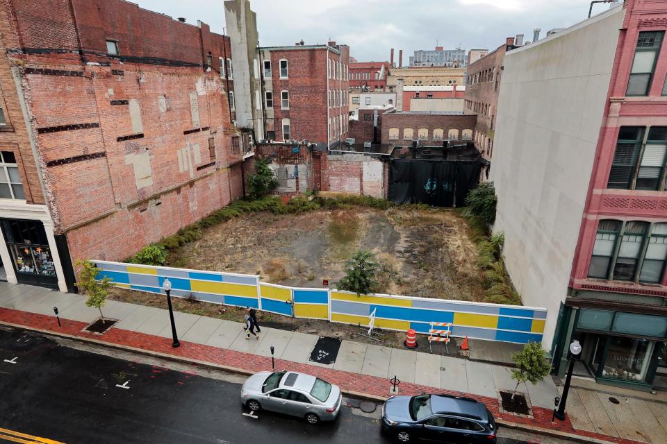 Two people are seen walking up Union Street in New Bedford, past the empty lot where the Keystone building was located.