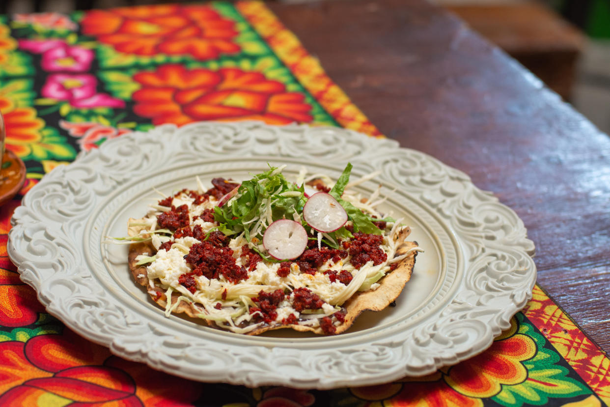 Tlayuda is a Mexican dish made from a partially fried or toasted tortilla topped with refried beans, meat, vegetables and cheese. (Photo: Getty Creative)