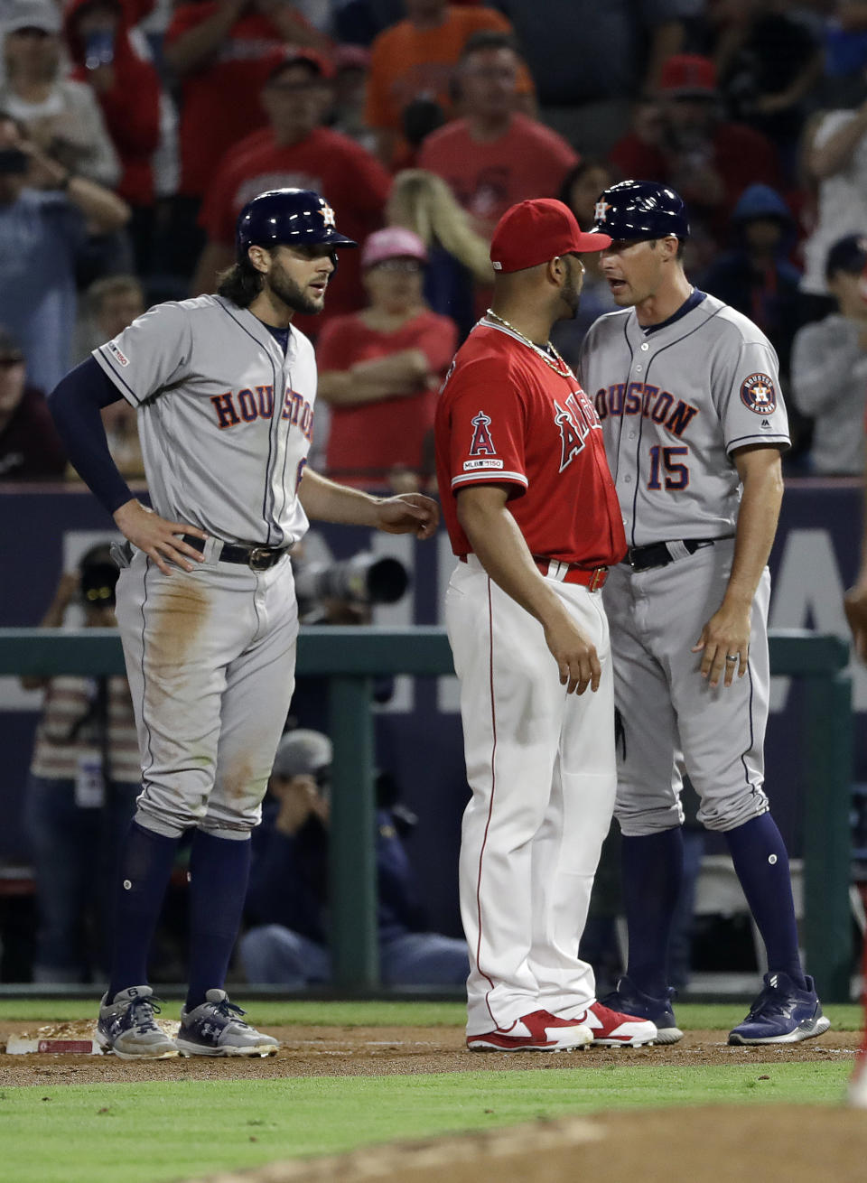 Los Angeles Angels first baseman Albert Pujols, center, argues with Houston Astros first base coach Don Kelly (15) after Astros' Jake Marisnick, left, was hit by a pitch on Tuesday in Anaheim, Calif. (AP Photo/Marcio Jose Sanchez)