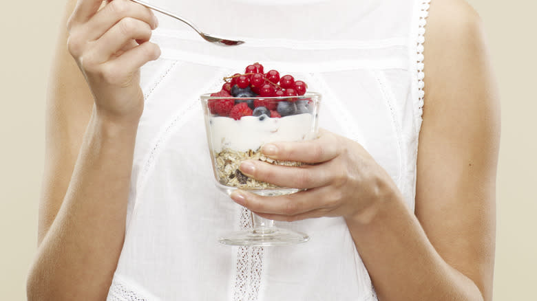 eating yogurt dessert with berries