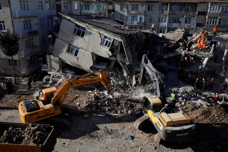 Rescue workers search the site of a collapsed building, after an earthquake in Elazig