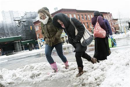 Pedestrians climb over slush and snow in the Brooklyn borough of New York, February 5, 2014. REUTERS/Keith Bedford