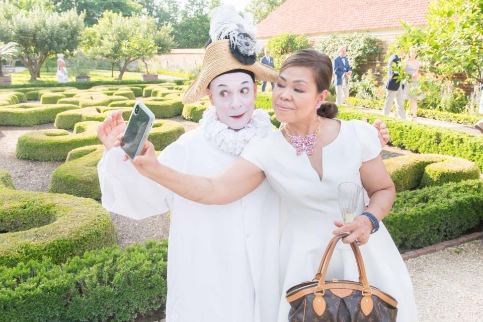 A mime and White House Chef Cristeta Comerford pose for a photograph.