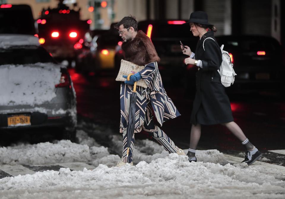 Guests heading to a fashion show cross a slushy intersection as they arrive at the Skylight Clarkson Square during Fashion Week, Thursday, Feb. 9, 2017, in New York. (AP Photo/Julie Jacobson)