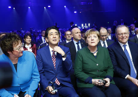 German Chancellor Angela Merkel and Japanese Prime Minister Shinzo Abe attend the opening ceremony of the CeBit computer fair, which will open its doors to the public on March 20, at the fairground in Hanover, Germany, March 19, 2017. REUTERS/Morris Mac Matzen